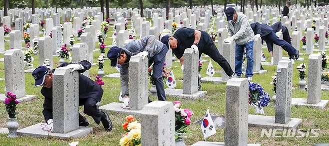 [서울=뉴시스] 정병혁 기자 = 지난 6월1일 오전 서울 동작구 국립서울현충원에서 송파구 국가유공자들이 베트남 전쟁에 참전한 전우들의 묘역 정비를 하고 있다. 2023.08.16. jhope@newsis.com