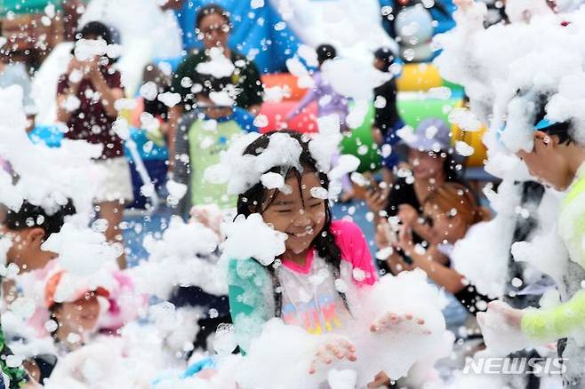 [부산=뉴시스] 하경민 기자 = 부산지역에 엿새째 폭염주의보 발효 중인 16일 남구 용호별빛공원에서 열린 '2023년 남구 물놀이 축제'를 찾은 어린이들이 인체에 무해한 거품 눈을 맞고 있다. 오는 20일까지 운영되는 물놀이축제에는 수영장 4개와 워터슬라이드, 페달보트, 챌린저바운스 등 물놀이 시설을 비롯해 물총싸움과 마술공연, 댄스공연 등 부대행사도 마련된다. 2023.08.16. yulnetphoto@newsis.com