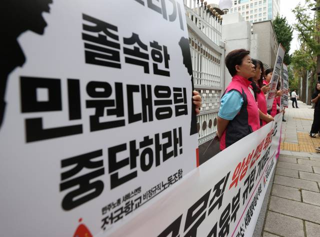 16일 오전 서울 종로구 정부서울청사 후문에서 민주노총 서비스연맹 전국학교비정규직노동조합이 연 '교육공무직 악성 민원 욕받이로 내모는 교육부 규탄 기자회견'에서 참가자들이 손팻말을 들고 있다. 연합뉴스