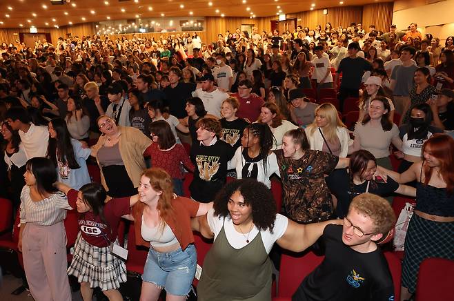 지난 6월 서울 성북구 고려대에서 열린 2023 국제하계대학 입학식에 참석한 각국 학생들이 응원 동작을 배우며 어깨동무하고 있다. 정부는 2027년까지 국내 외국인 유학생을 30만명으로 늘리기 위한 ‘유학생 교육 경쟁력 방안’을 16일 발표했다./연합뉴스