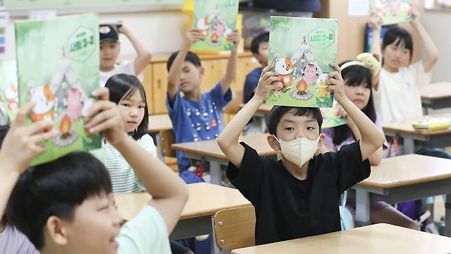 여름방학이 끝나고 개학한 이의초등학교에서 3학년 1반 학생들이 2학기 교과서를 들어보이고 있다. 뉴스1