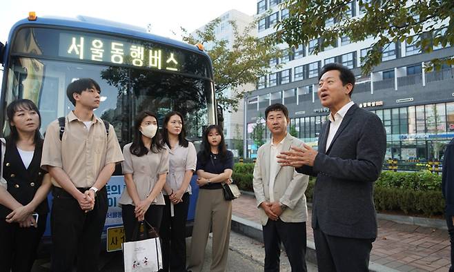 오세훈 서울시장(오른쪽)이 17일 오전 경기 김포시 풍무동에서 출발하는 서울동행버스 02번에 탑승하기 전 시민들에게 버스 운행 취지에 관해 설명하고 있다. 서울시 제공