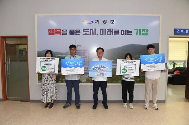 정종복 기장군수(왼쪽 세 번째)와 군청 직원들이 ‘수산물 소비·어촌휴가 장려 캠페인’ 참여 인증 사진을 찍고 있다.