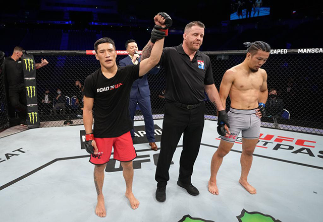 이자(왼쪽)가 사스 게이스케와 Road to UFC 시즌1 페더급 8강 승리 선언을 받으며 기뻐하고 있다. 사진=Zuffa