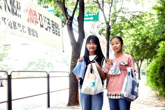 오윤서(왼쪽)·구시연 학생기자가 폐현수막을 활용한 업사이클링에 대해 배우고 폐현수막 에코백·파우치를 장식해봤다.