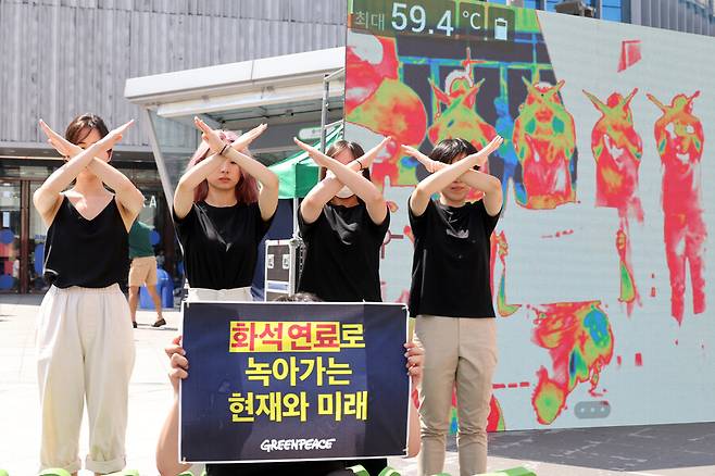 오는 22일 에너지의날을 앞두고 21일 오전 서울 서대문구 스타광장에서 그린피스 활동가들이 빠른 화석연료 퇴출과 정부의 올바른 에너지 정책 및 기후 대응을 촉구하는 행위극을 하고 있다. 이 모습을 열화상 카메라로 찍은 화면이 뒤에 보인다. 김혜윤 기자 unique@hani.co.kr