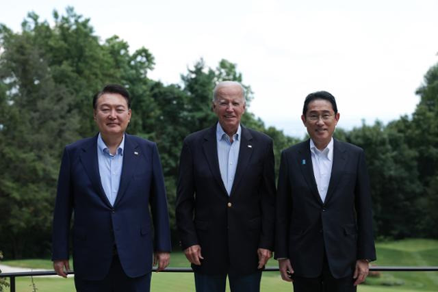 윤석열(왼쪽부터) 대통령과 조 바이든 미국 대통령, 기시다 후미오 일본 총리가 18일(현지시간) 미국 워싱턴 인근 대통령 별장인 캠프 데이비드에서 한미일 정상 오찬에 앞서 기념촬영을 하고 있다. 대통령실 제공