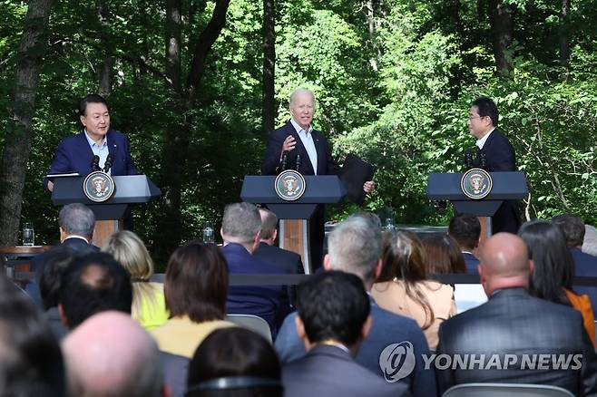 답변하는 바이든 대통령 (캠프 데이비드=연합뉴스) 진성철 기자 = 조 바이든 미국 대통령이 18일(현지시간) 워싱턴DC 인근 미국 대통령 별장인 캠프 데이비드에서 열린 한미일 정상 공동기자회견에서 미국 취재진의 추가 질문에 답변하고 있다. 왼쪽부터 윤석열 대통령, 바이든 대통령, 기시다 후미오 일본 총리.  2023.8.20 zjin@yna.co.kr