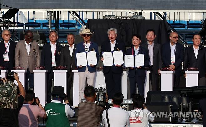 '강원·춘천세계태권도문화축제' 3자 협약식 지난 19일 강원 춘천시 송암 스포츠타운 주경기장에서 열린 '강원·춘천세계태권도문화축제' 개막식에서 조정원 WT 총재와 김진태 도지사, 육동한 시장이 3자 협약서에 서명한 뒤 기념 촬영. [연합뉴스 자료사진]