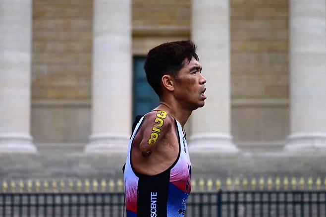 8월 19일(현지 시각) 파리에서 열린 2023 세계 장애인 트라이애슬론 올림픽 테스트 이벤트에서 한국의 김황태가 프랑스 국회의사당을 지나 달리고 있다./AFP 연합뉴스