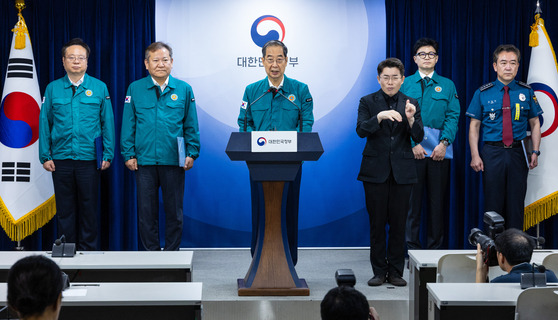 Prime Minister Han Duck-soo, center, speaks at the government complex in central Seoul on Wednesday on plans to tackle heinous crimes that target random people alongside National Police Agency Commissioner General Yoon Hee-keun, right, and other related ministers. [YONHAP]