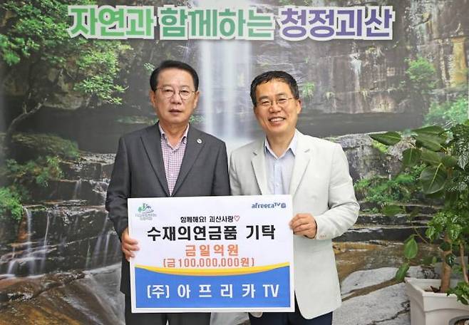 아프리카TV 서수길(오른쪽) CBO가 23일 괴산군청에서 송인헌 군수에게 1억원 상당의 수재의연금품 증서를 전달하고 있다. 아프리카TV