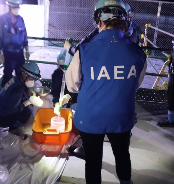 IAEA, 후쿠시마 오염수 샘플 채취 관찰 - 국제원자력기구(IAEA) 직원이 22일 일본 후쿠시마현 오쿠마에서 후쿠시마 원전 오염수(일본 정부 명칭 ‘처리수’)의 샘플 채취 과정을 관찰하고 있다. 기시다 후미오 총리는 오는 24일 오염수를 해양에 방류하겠다고 이날 발표했다. AFP 연합뉴스
