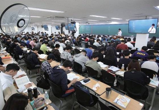 2년차 공시생 A씨는 “작년까지만 해도 학원 한 반에 수강생이 80명 정도 됐는데 지금은 반이나 줄었다. 인터넷을 뒤져보면 바늘구멍 통과해서 합격했더니 월급은 적고 일은 많다고 호소하는 내용이 많더라. 이런 현실이 알려지면서 다들 눈을 돌리는 것 같다”고 말했다. 사진은 지난 2017년 10월 노량진의 한 학원에서 수험생들이 수업을 듣고 있는 모습. / 사진:연합뉴스