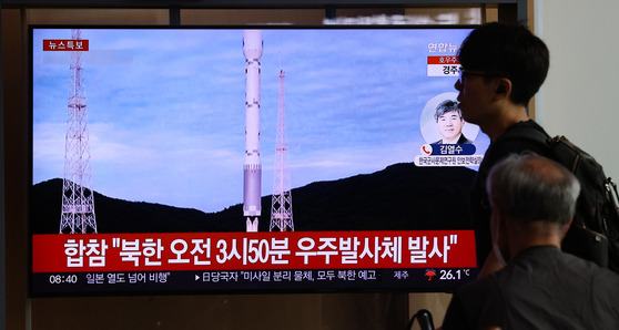 People at Seoul Station in central Seoul Thursday watch news about North Korea’s second attempt to launch a spy satellite from the Sohae satellite launching station in Cholsan County, North Pyongan Province, earlier that morning, which ultimately ended in failure. [YONHAP]