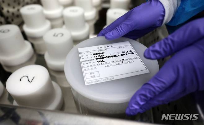 [서울=뉴시스] 김선웅 기자 = 일본이 후쿠시마 오염수 방류를 시작한 24일 서울 서초구 서울특별시 보건환경연구원에서 관계자가 식품 방사능 안전성을 검사하기 위해 오염 수치 확인용 고순도 게르마늄 감마핵종 분석기에 시료를 넣고 있다. 2023.08.24. mangusta@newsis.com