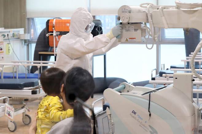 경기도의료원 수원병원에 마련된 '코로나19 재택치료 단기외래 진료센터'에서 의료진이 어린이 환자를 엑스레이 등을 이용해 진료하고 있다. [사진=뉴스1]