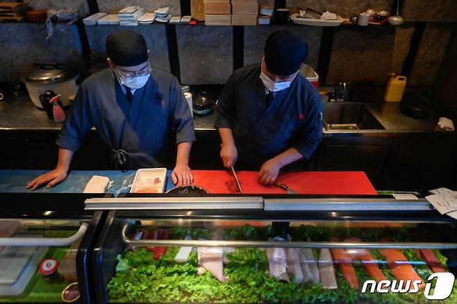 22일(현지시간) 중국 베이징의 한 일식집에서 요리사들이 회를 뜨고 있다. 203.08.22/ ⓒ AFP=뉴스1 ⓒ News1 권진영 기자