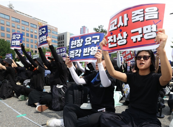 26일 오후 서울 영등포구 국회 앞에서 전국교사 일동이 연 ‘국회 입법 촉구 추모집회’에서 참가자들이 손팻말을 들고 있다. 2023.8.26 연합뉴스