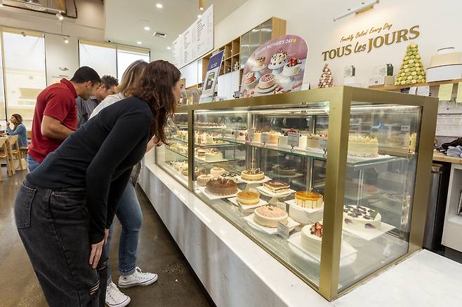 미국 뚜레쥬르 매장에서 다양한 디자인의 케이크를 보고 있는 현지인들 [뚜레쥬르 제공]