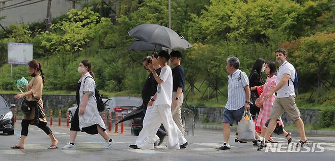 [서울=뉴시스] 김금보 기자 = 소나기가 내렸다 그치기를 반복한 22일 오후 명동역 인근에서 사람들이 우산을 쓰거나 접은 채 이동하고 있다. 2023.08.22. kgb@newsis.com