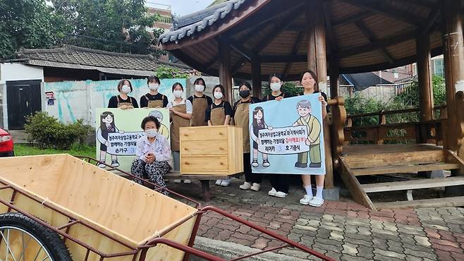 청주여자상업고등학교 목공 창업동아리 ‘아랫목’ 학생들이 지난달 6일  직접 제작한 손수레를 지역 주민에게 전달하고 기념사진을 찍고 있다. 아랫목 제공.