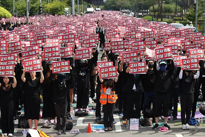 지난 26일 오후 서울 영등포구 국회 앞에서 전국교사 일동이 연 ‘국회 입법 촉구 추모집회’에서 참가자들이 손팻말을 들고 있다. 연합뉴스