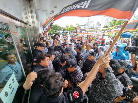 보훈단체 등 13개 단체가 30일 광주광역시청 앞에서 정율성 역사공원 조성사업 중단 집회를 마친 뒤 성명서 전달을 위해 청사 진입을 시도하면서 청원경찰과 대치하고 있다. 황희규 기자