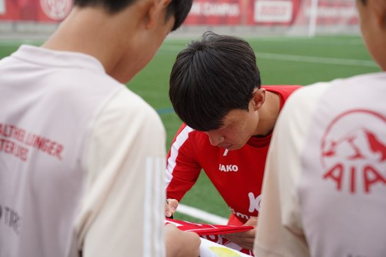 팀 차붐 독일원정대 멤버가 축구대표팀 2선 공격수 이재성과 함께 하는 트레이닝 세션 직후 유니폼에 사인을 받고 있다. 사진 풋웍크리에이션