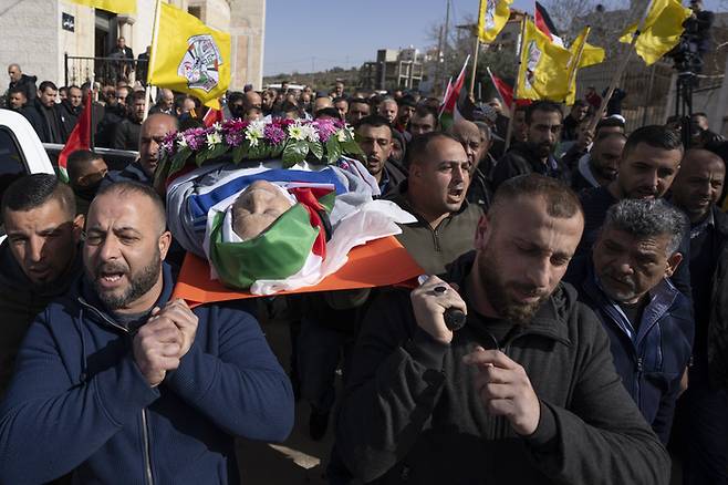 지난해 1월13일(현지시간) 팔레스타인 요르단강 서안지구에서 열린 팔레스타인계 미국인 오마르 압둘라마지드 아사드의 장례식에서 추모객들이 시신을 옮기고 있다. AP연합뉴스