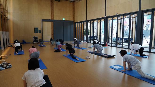 Seongbuk-gu residents take a yoga class on May 11 at Jongam Square. (Park Yuna/The Korea Herald)