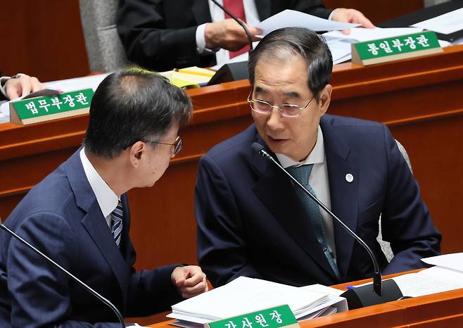 한덕수 국무총리가 30일 국회에서 열린 예산결산특별위원회 전체회의에서 최재해 감사원장과 대화하고 있다. [연합뉴스]