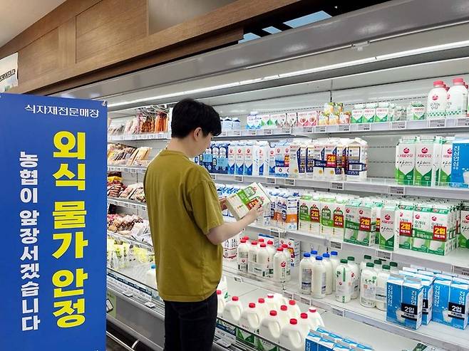 농협은 오는 10월부터 전국 하나로마트 매장의 흰우유 대표 품목((900~1000㎖/1팩 기준)을 2,980원 이하로 판매할 예정이다. 하나로마트 신촌점에 방문한 고객이 매대에 진열된 우유 상품을 살펴보고 있다. 농협 제공