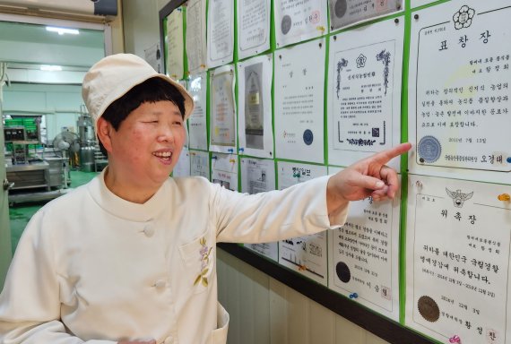 함정희 박사가 지난 4월21일 전북 전주 팔복동에 있는 자신의 생산공장 안에 모아둔 표창과 상장 등에 대해 설명하며 웃고 있다. 사진=강인 기자