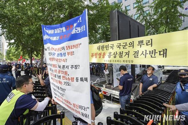 보수단체 한 관계자가 31일 오후 서울 영등포구 광복회관 앞에서 열린 이종찬 광복회장 망언 규탄 및 퇴진 요구 국민대회에서 광복회 회원들을 향해 팻말을 들어보이고 있다.