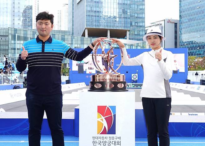 지난 2019년 열린 ‘현대차 정몽구배 한국양궁대회 2019’ 우승자 김우진 선수(왼쪽), 김나리 선수가 트로피와 함께 기념 사진을 촬영하고 있다. [현대차그룹 제공]