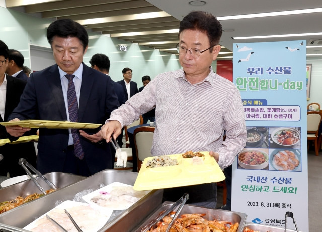 이철우 경북지사(오른쪽)가 31일 경북도청 구내식당에서 국내산 수산물을 메뉴로 한 특식을 식기에 담고 있다. 경북도 제공