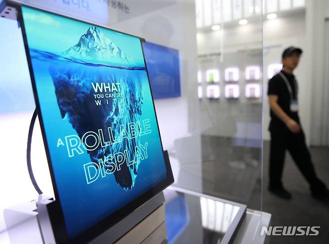 [서울=뉴시스] 김진아 기자 = 16일 서울 강남구 코엑스에서 열린 K-Display 2023 한국디스플레이산업전시회에서 관람객들이 삼성디스플레이의 롤러블 디스플레이를 보고 있다. 이번 전시회는 역대 최대인 172개사가 참여해 582부스 규모로 진행되며, 국내 양대 패널기업과 국내외 소부장 기업들이 OLED(유기발광다이오드) 관련 다양한 신기술·신제품을 다수 선보일 계획이다. 2023.08.16. bluesoda@newsis.com