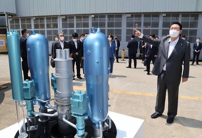 윤석열 대통령이 신한울 3·4호기 원자로와 증기발생기용 주단소재 보관장에서 한국형원전 APR1400 축소 모형을 살펴보며 설명을 듣고 있다. 연합뉴스