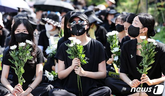 2일 서울 여의도 국회의사당 앞에서 열린 서이초 교사 추모 및 입법촉구 7차 교사 집회에서 서이초 교사의 대학원 동기들이 국화를 들고 있다. 2023.9.2/뉴스1 ⓒ News1 허경 기자