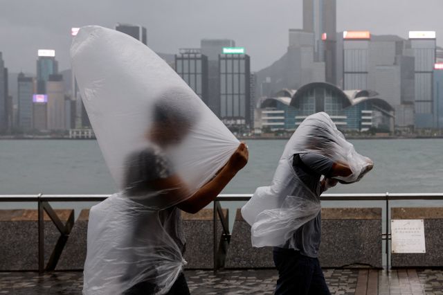 홍콩 시민들이 지난 1일 제9호 태풍 ‘사올라’의 강풍과 비를  피하며 이동하고 있다. 로이터연합뉴스