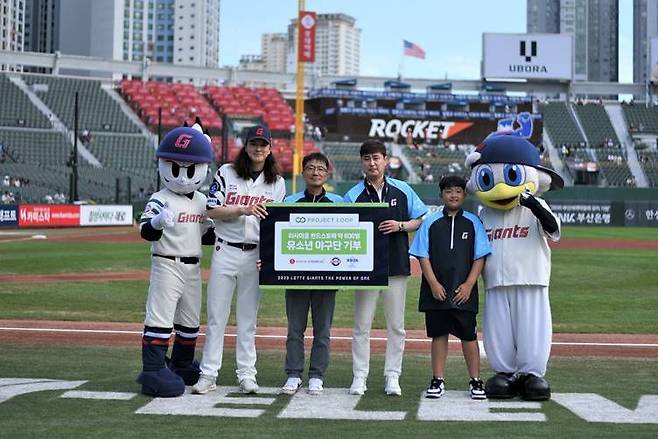 3일 부산 사직구장에서 열린 ‘자이언츠 LOOP DAY’에서 김원중(왼쪽 2번째) 롯데자이언츠 선수, 최영광(왼쪽 3번째) 롯데케미칼 커뮤니케이션부문장, 정신(왼쪽 4번째) 부산광역시 야구소프트볼협회 회장, 김도윤(왼쪽 5번째) 기장시 리틀야구단 선수가 기념사진을 촬영하고 있다. /롯데케미칼 제공