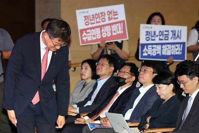 이기일 보건복지부 1차관이 1일 서울 강남구 코엑스에서 열린 보건복지부 산하 국민연금 재정계산위원회의 국민연금 재정계산위원회 공청회에서 인사하는 하는 뒤로 양대노총 조합원들이 수급연령 상향 반대 관련 피켓을 들고 있다. 보건복지부는 이날 공청회에서 여러 의견을 수렴한 뒤 오는 10월까지 국민연금 개혁 방안인 종합운용계획을 마련할 예정이다. 2023.09.01. [서울=뉴시스]