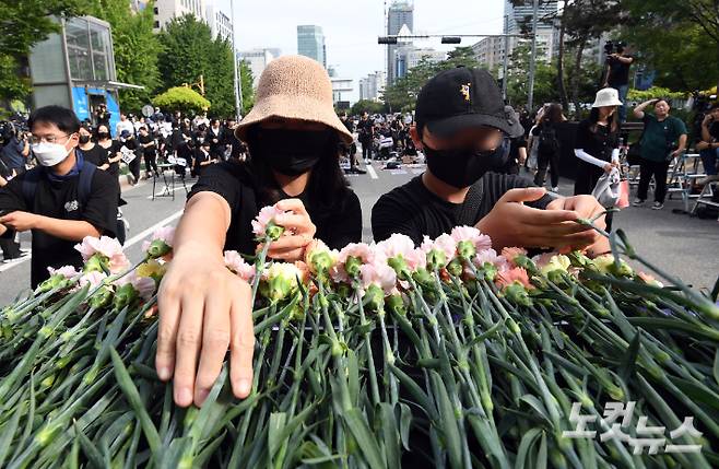 4일 오후 국회 앞에서 열린 '고 서이초 교사 추모집회' 에 참가한 교사들이 카네이션 헌화를 하고 있다. 황진환 기자