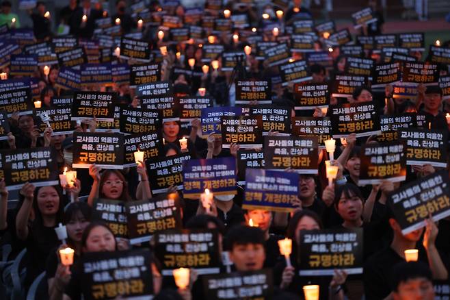 서울 서이초등학교 교사의 49재 추모일인 4일 오후 서울 서초구 서울교육대학교에서 열린 촛불문화제에서 참가자들이 촛불과 피켓을 들고 구호를 외치고 있다. 연합뉴스