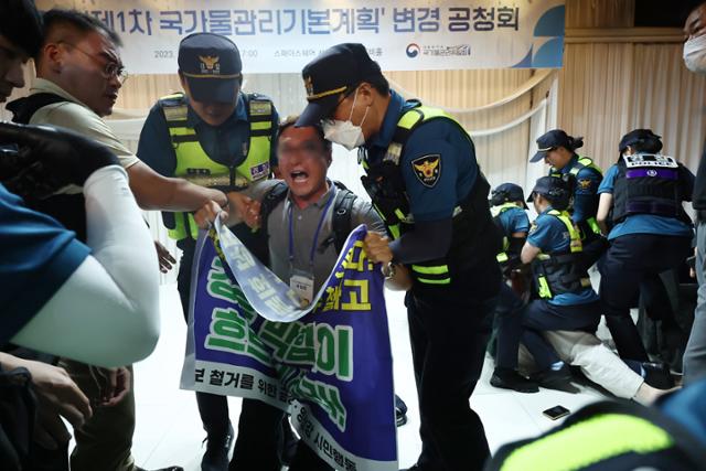 5일 오후 제1차 국가물관리기본계획 변경안 공청회가 열린 서울 중구 스페이스쉐어 서울중부센터에서 공청회 중단과 변경안 철회를 요구하는 환경단체 회원들을 경찰이 제지하고 있다. 연합뉴스