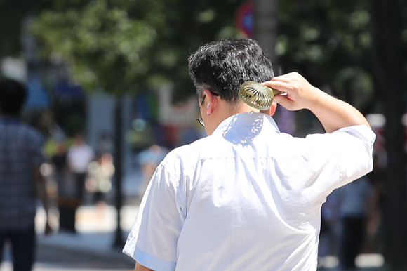 서울 종로구 광화문광장에서 한 시민이 선풍기를 목에 쐬고 있다. [사진=뉴시스]