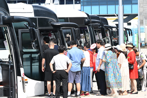 Chinese group tourists board rental buses to tour downtown Jeju on Aug. 31. [YONHAP]