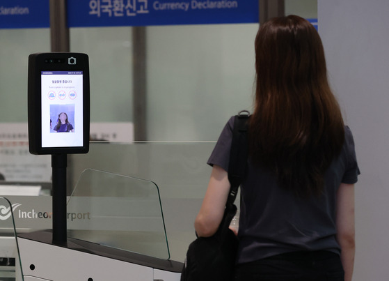 A customer enters the boarding gate using the Smart Pass service on July 10. The Smart Pass service allows passengers to enter the boarding gate by scanning their faces. [YONHAP]