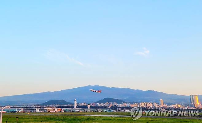 제주공항 너머 한라산 (제주=연합뉴스) 구름 한 점 없는 화창한 날씨 속에 제주공항 너머로 한라산이 자태를 뽐내고 있다. [연합뉴스 자료사진]